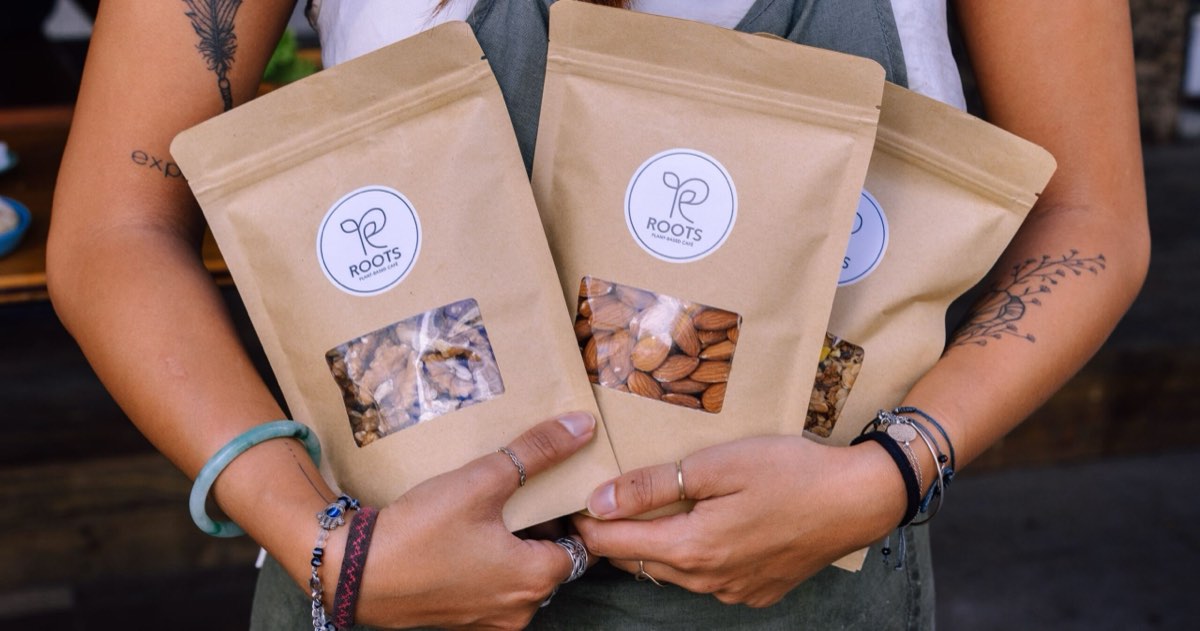 A ROOTS team member holding packaged nuts