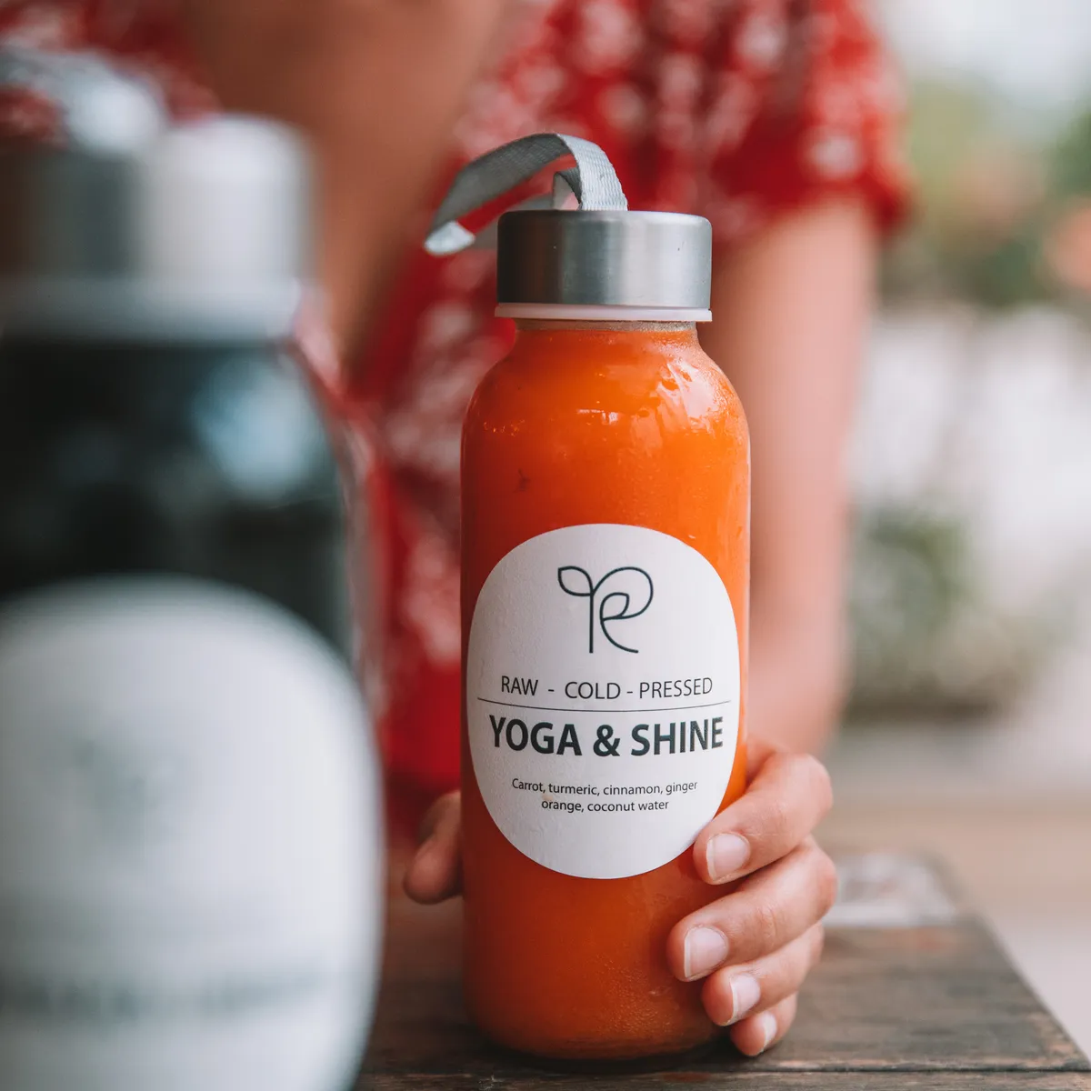 Cold-pressed Yoga & Shine juice held in hand